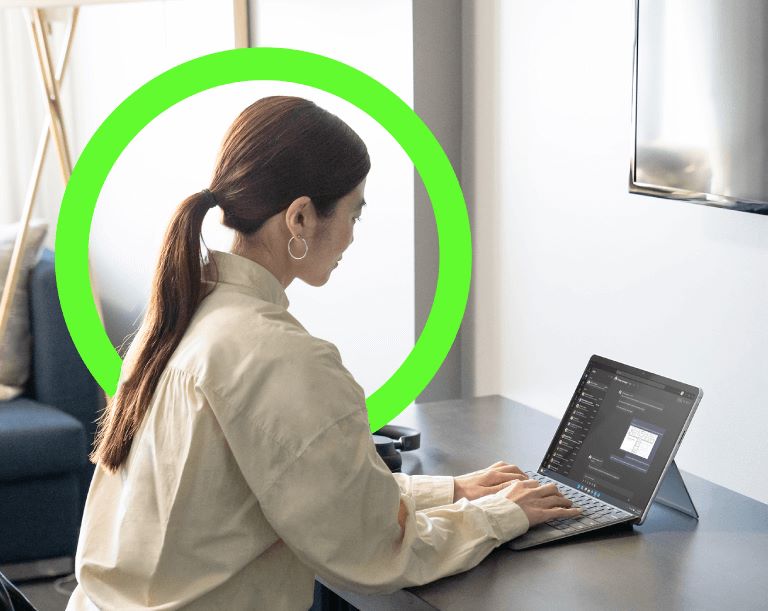 Photograph of a person using a Surface Laptop 9, with a Cantium branded, green circle around their head.